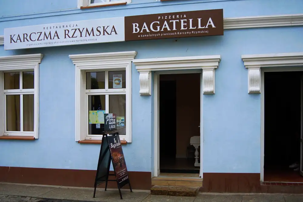 Kamienica z szyldami Restauracja Karczma Rzymska i Pizzeria Bagatella przy ul. Powstańców Warszawskich