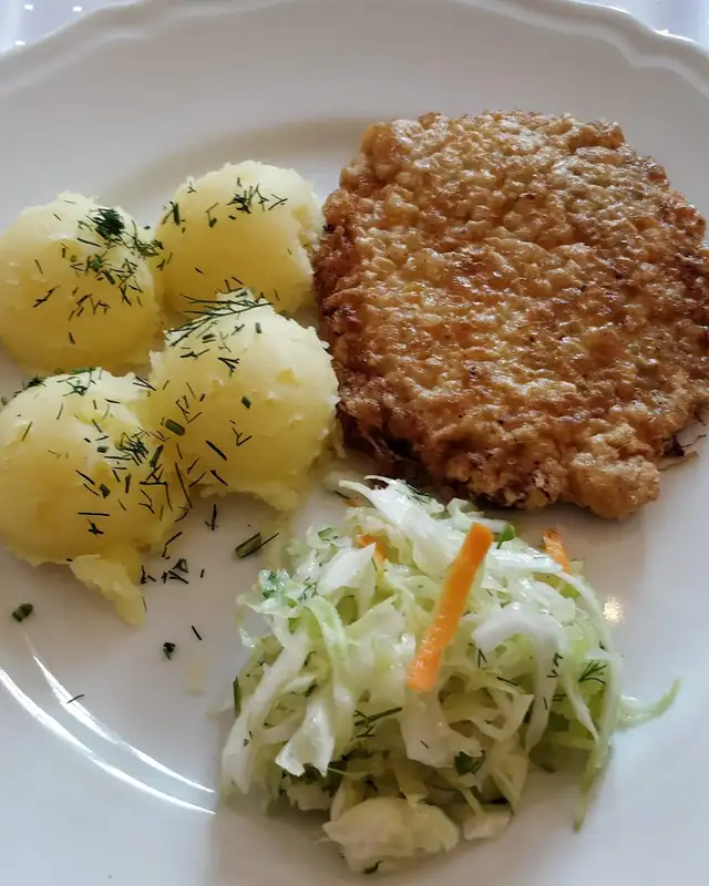 Kotlet w chrupiącej panierce z młodymi ziemniakami i surówką